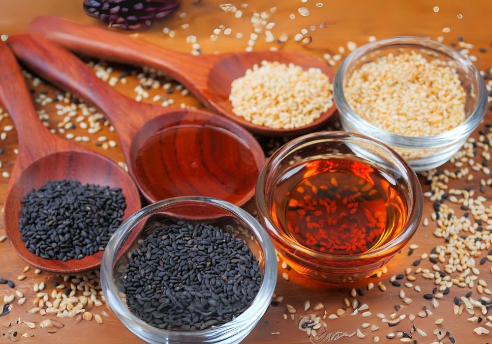 Três potes, um com óleo de gergelim e dois com gergelim, uma com gergelim preto outra com gergelim branco; e três colheres de pau, uma com óleo de gergelim e duas com gergilim, um com gergelim branco e outro com gergelim preto.