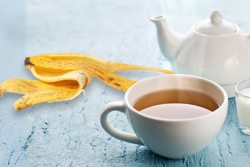 Uma xícara chá de casca de banana e uma casca de banana ao lado.